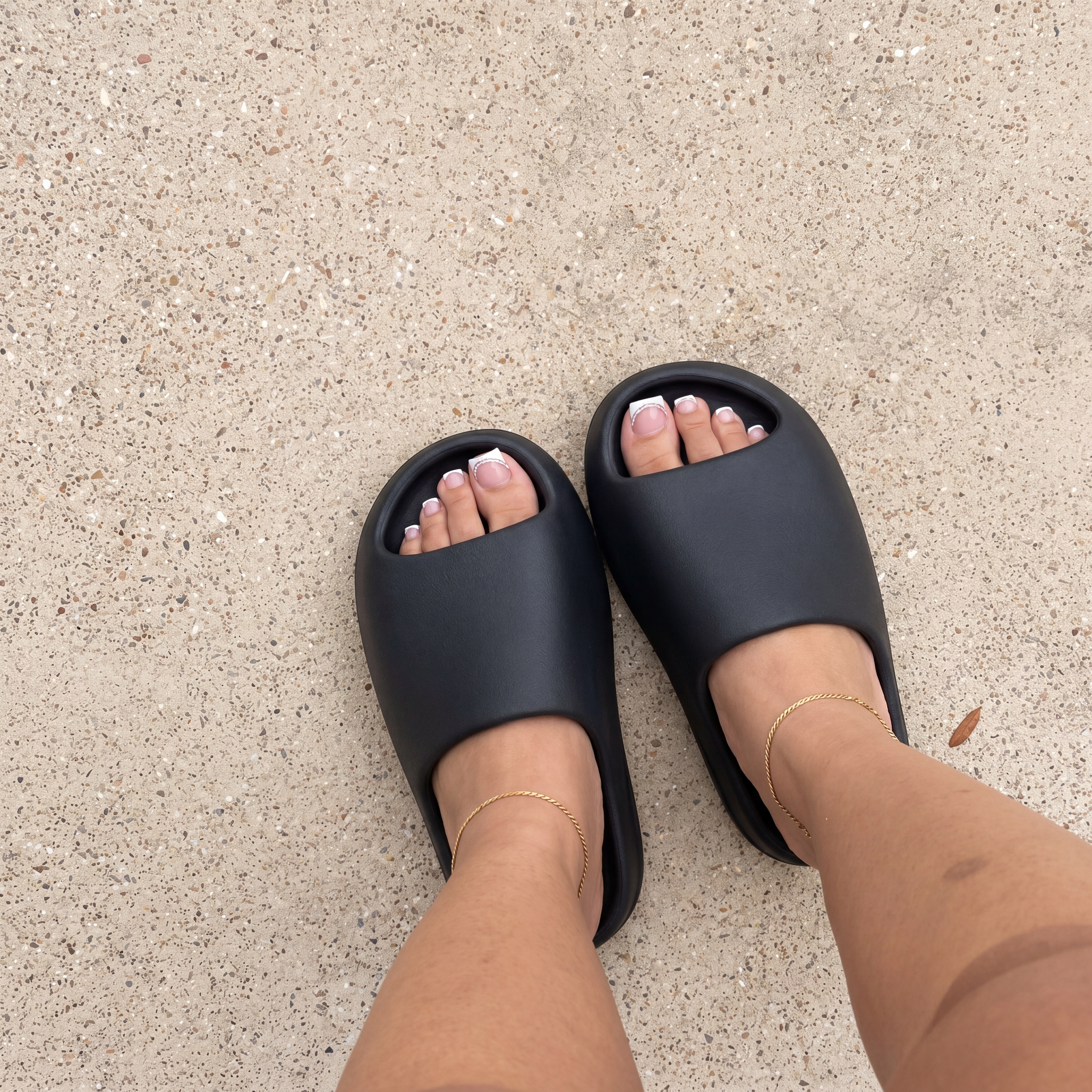 Female model wearing YS-01 Yeezy Slides in black colorway 